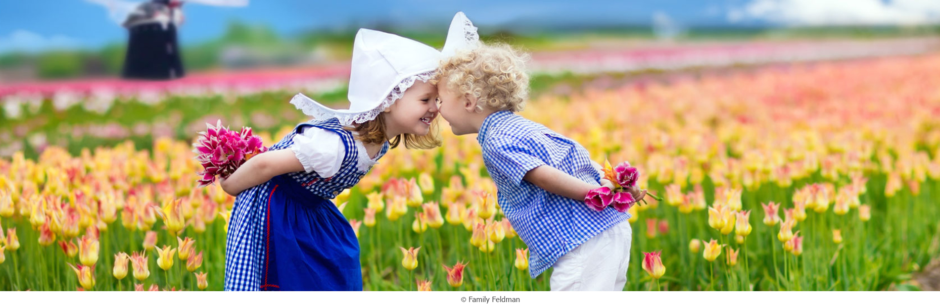 2 holländische Kinder in Tracht vor blühenden Tulpen